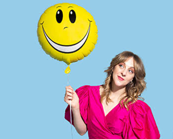 2010 Music Theatre graduate Gillian Cosgriff holding a balloon with a smiley face on it
