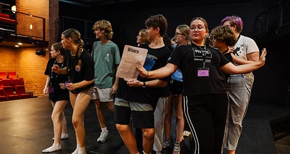 A group of students rehearsing on stage