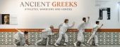 Holland Brooks in front of Ancient Greeks sign with other performers dressed in white.