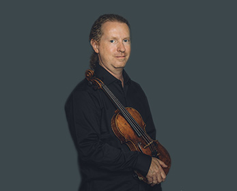 Zak Rowntree holding a violin.